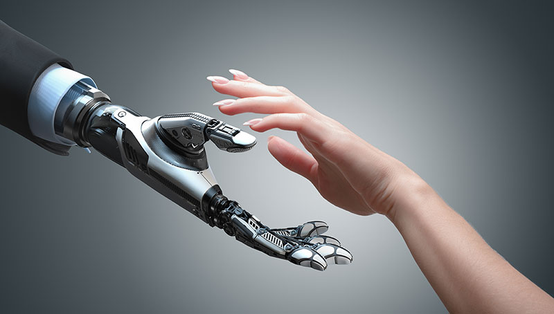 Roboterhand und menschliche Hand, die kurz vorm Händedruck sind
